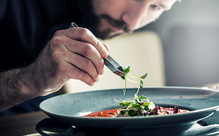 cocinero emplatando un plato de comida