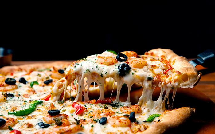 pizza cortada con queso fundido y aceitunas negras