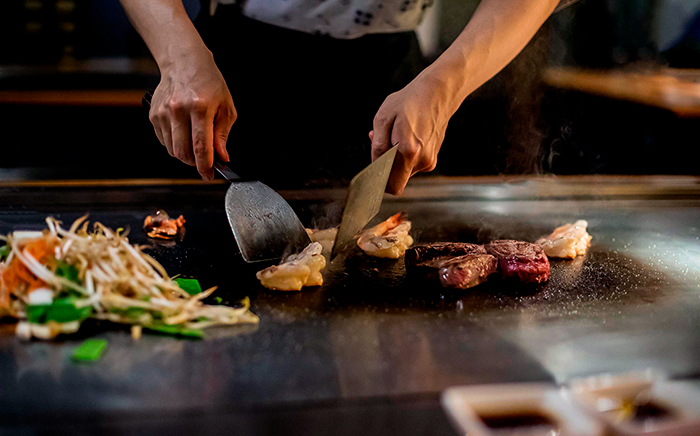 cocinero cocinando en una plancha tappanyaki