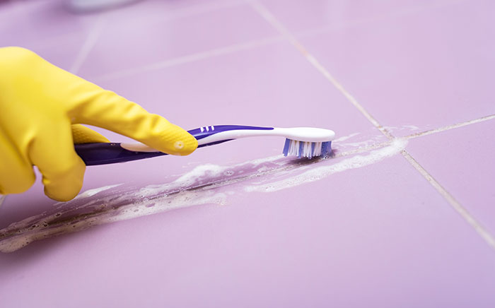 cepillo dientes limpiando azulejos