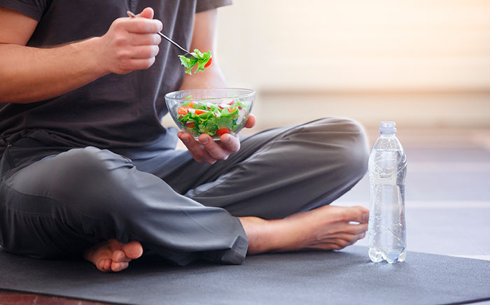 persona sentada comiendo ensalada