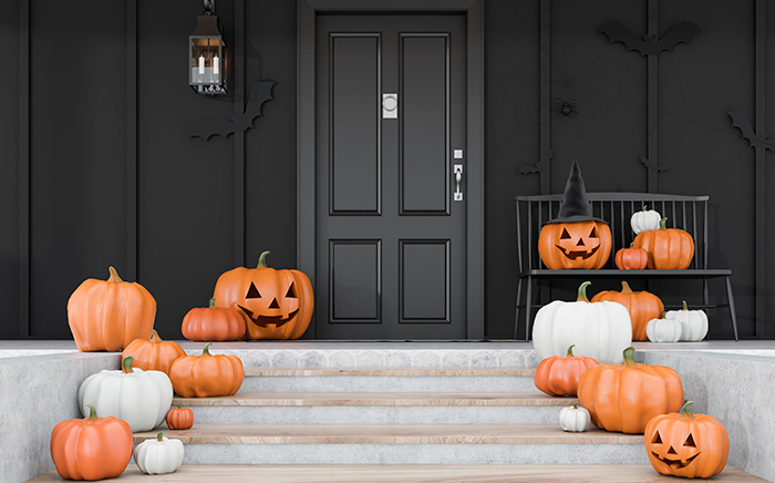 puerta negra de casa decorada con calabazas de halloween