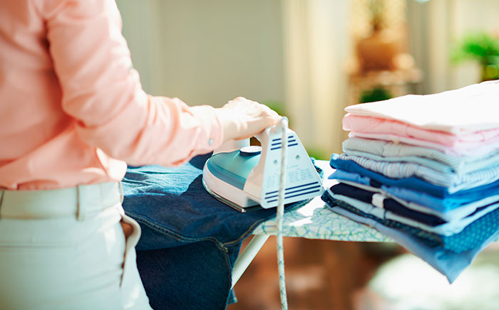 mujer planchando un pantalón