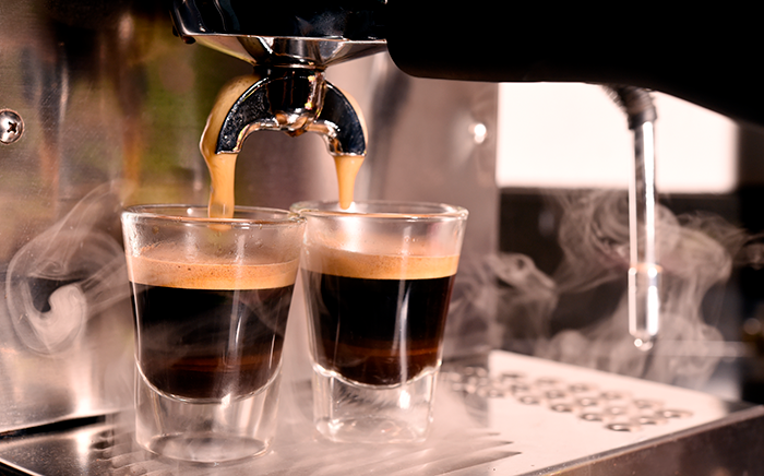 cafetera espresso con dos vasitos de café de cristal con café en el interior