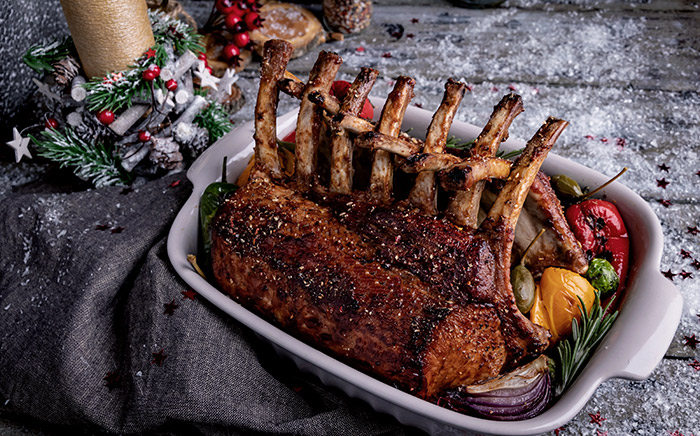 cordero asado en una bandeja de horno con adornos navideños