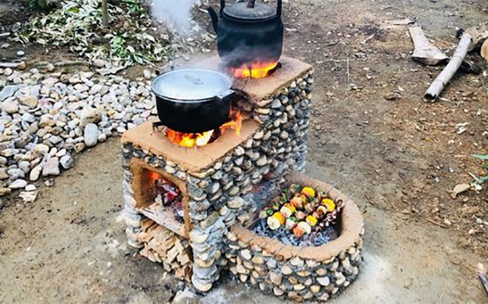 cocina de ladrillo con comida y una olla encima