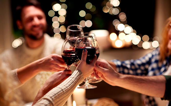 personas brindando con copas de vino en navidad