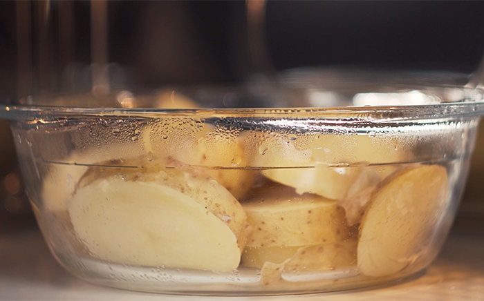 patatas en una fuente de cristal en un microondas