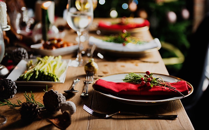 mesa decorada para navidad con plano close de un plato con una servilleta roja