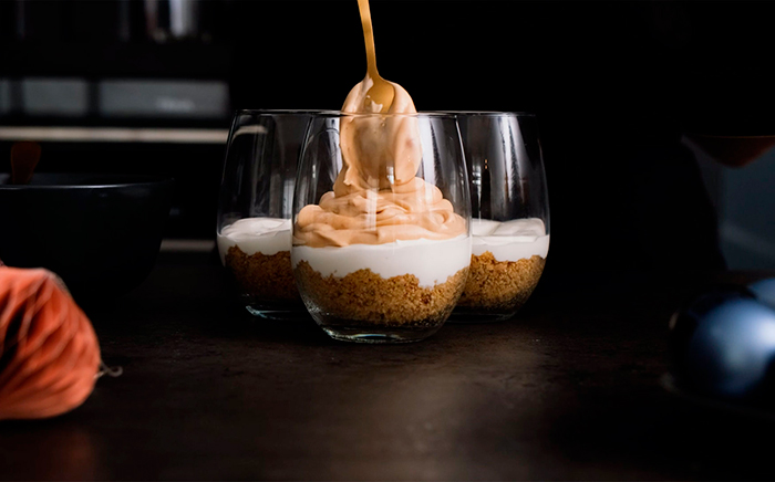 vasitos de cristal con mousse de chocolate echado con una cuchara