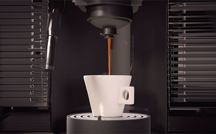 taza de café en una cafetera compacta integrada de cápsulas con café cayendo
