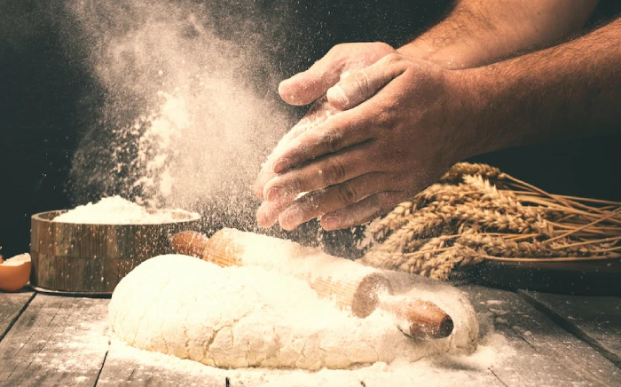 Hands with flour ready to knead a dough that will become eventually bread