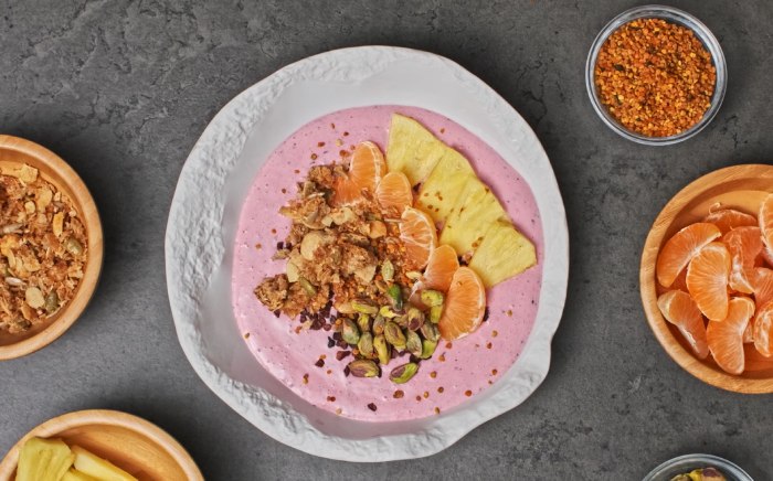 Bowl de frutas saludable de color rosa con semillas de chía y chips de chocolate