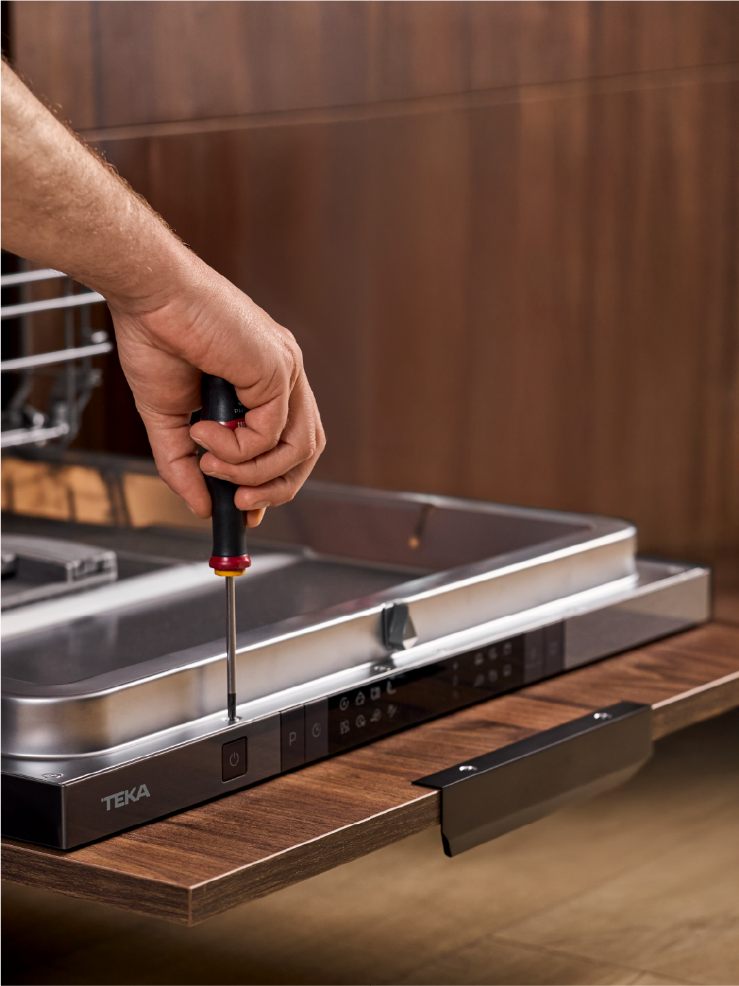 servicio técnico de repuestos Teka, hombre reparando en un lavavajillas