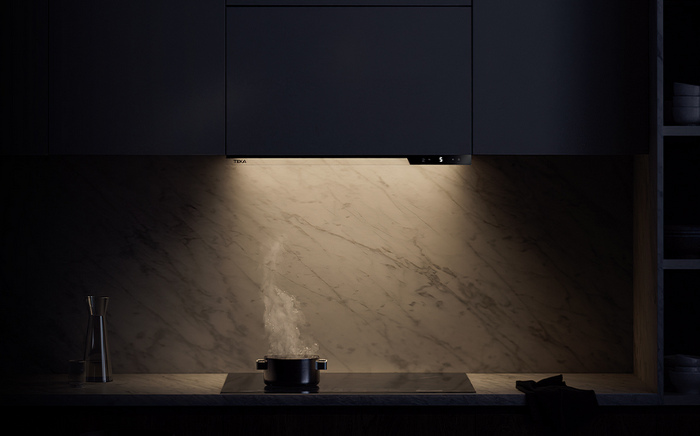 Plano medio placa iluminada solo con luz LED de campana extractora Integra Pro de Teka con humo de cacerola ascendiendo hacia la campana