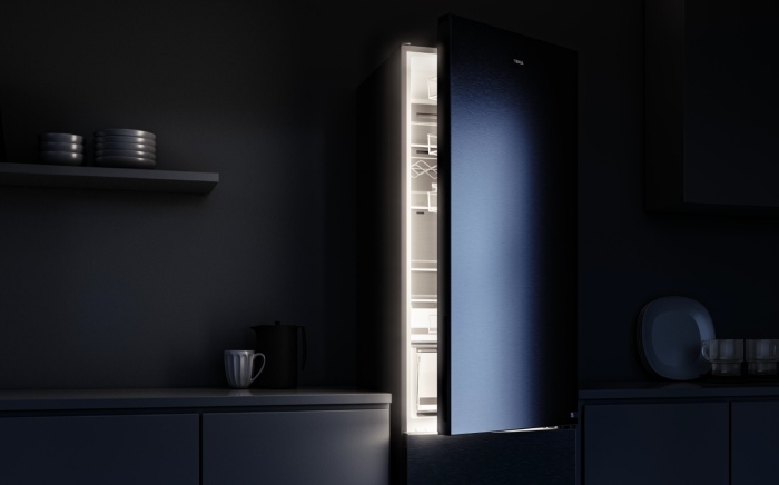 frigorífico In-Line slot in de Teka a oscuras con la puerta parcialmente abierta y lud LED emanando del interior.