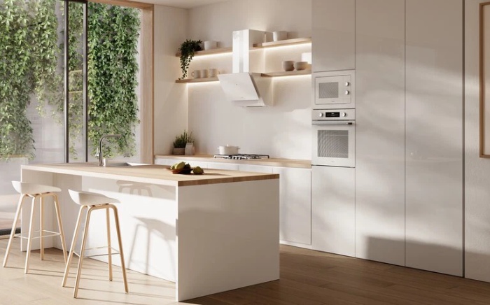 Frigorífico encastrable de Teka en una cocina blanca con isla y luz natural