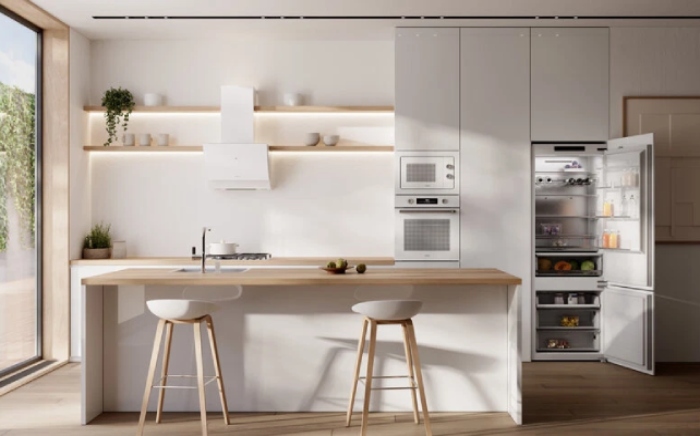 Cocina blanca con isla tipo barra y electrodomésticos Teka integrados en una sola pared
