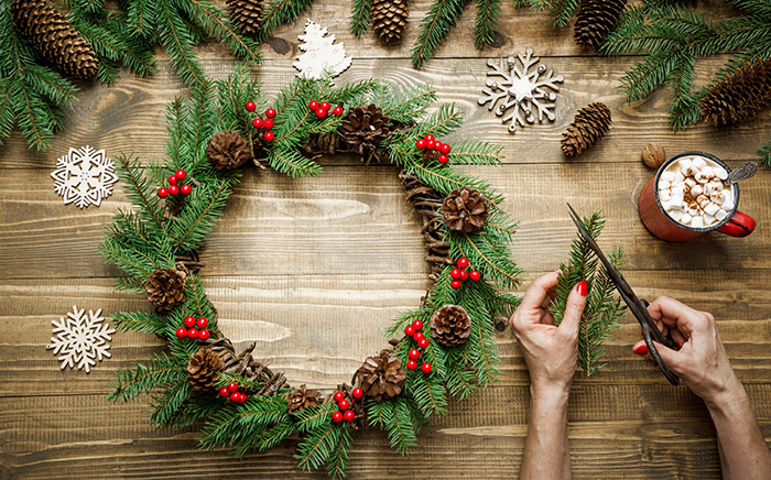 Woman arranged a do-it-yourself- Christmas decoration wreath from natural materials
