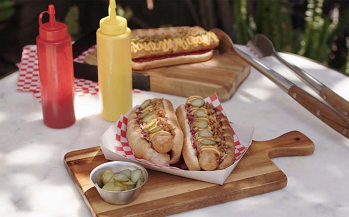 Barbecue hot dogs with ketchup and mustard and some pickles