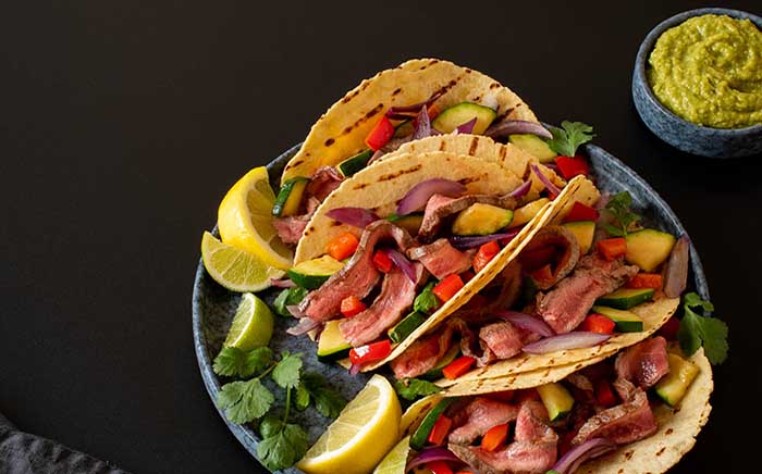 Beef tacos cooked on a gas barbecue or a charcoal barbecue with guacamole and coriander