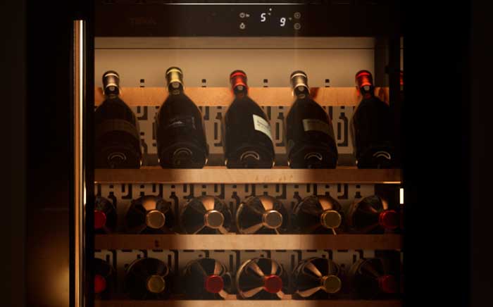 Bottles displayed on a wine cooler wooden shelves