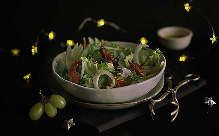 Christmas salad with LED lights on the background and some green grapes