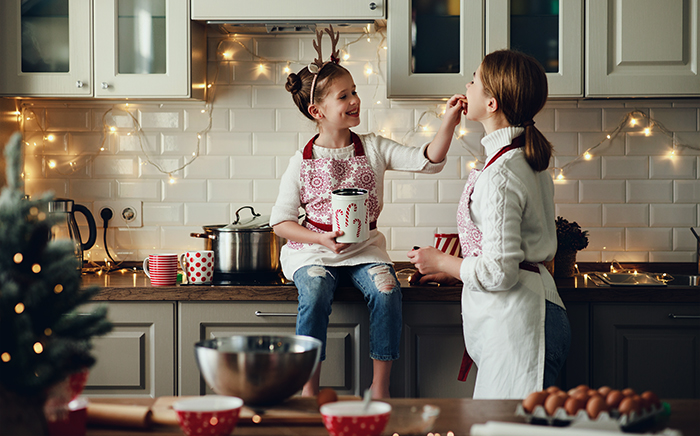 Woman and girl having fun in the kitchen preparing Christmas meals
