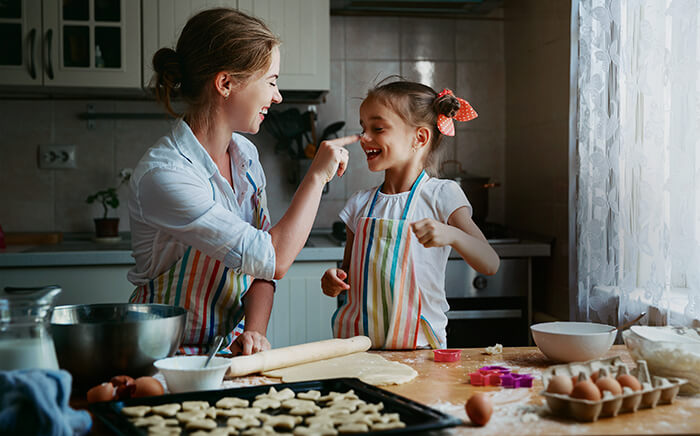 Mother and daughter playing with flour in the kitchen