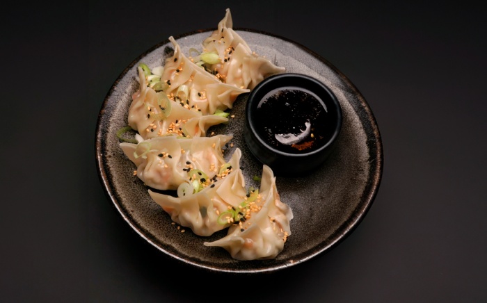 A black plate with steamed homemade gyozas 