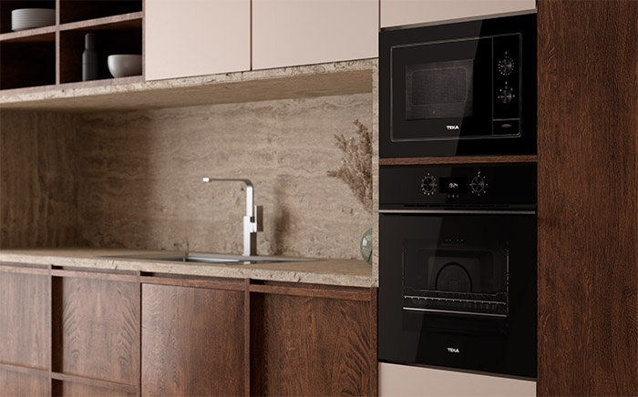 Kitchen in dark wood tones with Teka black oven and microwave in column