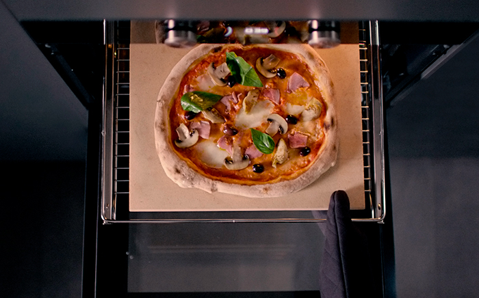 A margherita pizza on a Teka pizza stone ready to be placed inside MaestroPizza oven