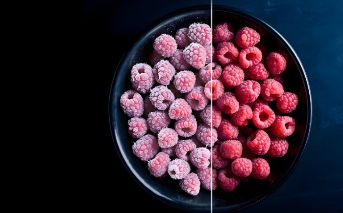 Split view of a bowl of raspberries comparing frost-covered frozen raspberries on the left side with fresh red raspberries on the right side.