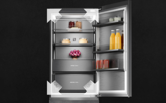 Interior view of an In-LIne, slot-in fridge by Teka open with shelves and door storage, featuring white directional arrows to highlight spacious capacity.