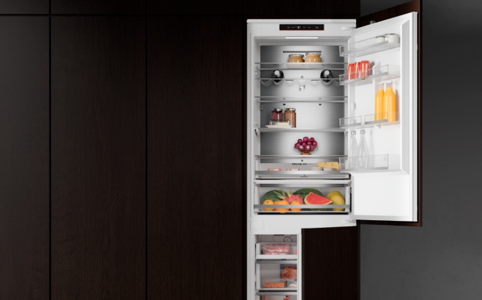 Open slot-in, In-Line series Teka fridge freezer showing organised food shelves and drawers.