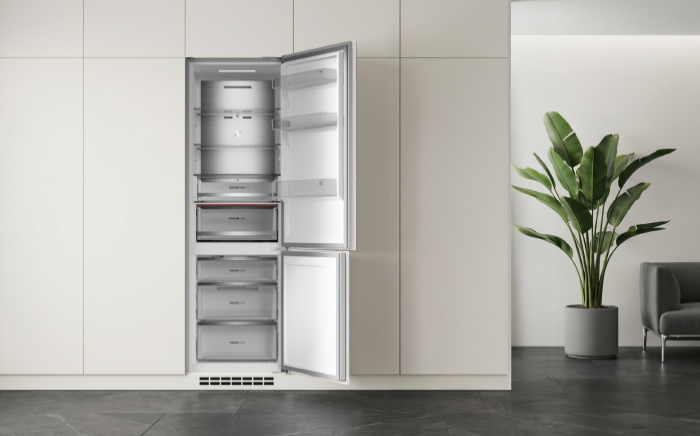 Built-in Max fridge-freezer refrigerator by Teka integrated into white modern cabinetry with both upper and lower doors wide open, revealing stainless steel shelving, crisp drawers, and freezer compartments.