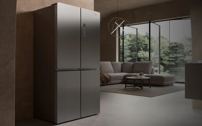 Freestanding grey four-door fridge freezer with a control panel, a VarioPro fridge by Teka, set in a modern living space.