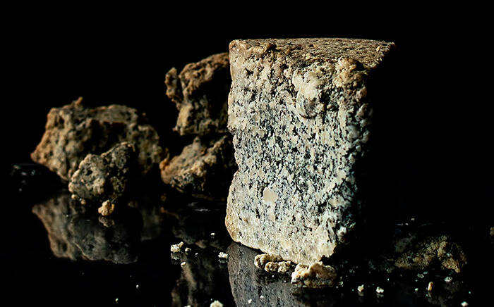 A piece of blue cheese over a black surface
