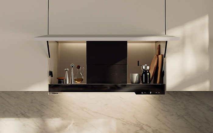 Open white cabinet over the hob where you can see part of the integrated hood and store space for dressing food and other cooking tools