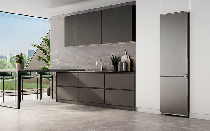 Kitchen with a garden view and stainless steel fridge in a grey and white atmosphere