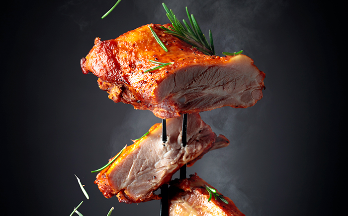 Carne grigliata servita con forchettone da barbecue